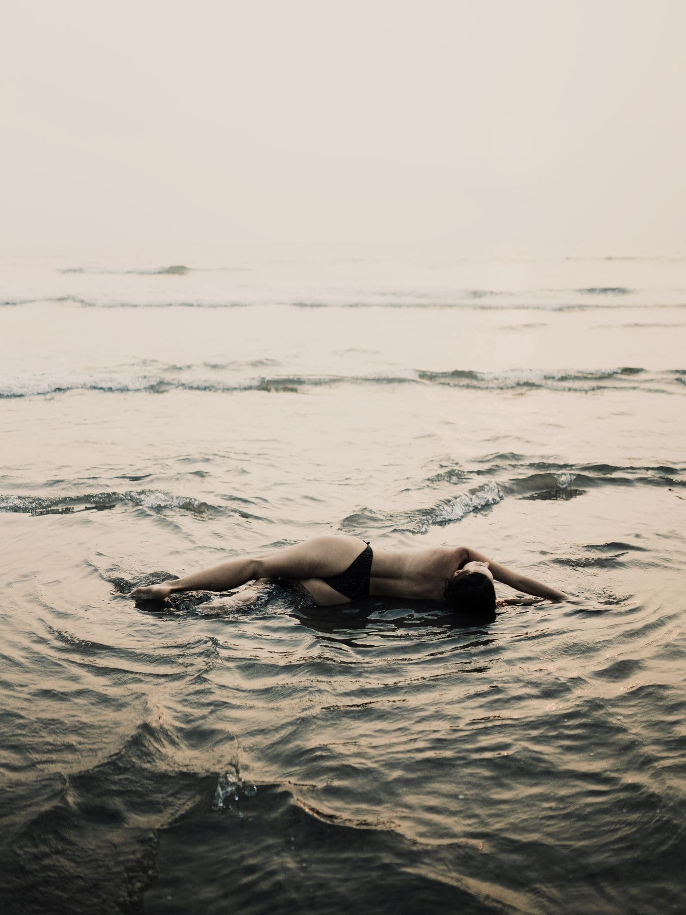 A person meditating quietly beside the ocean